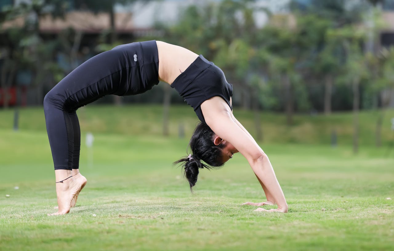 South Asian woman practicing yoga outdoors in Bengaluru park, displaying flexibility and strength.