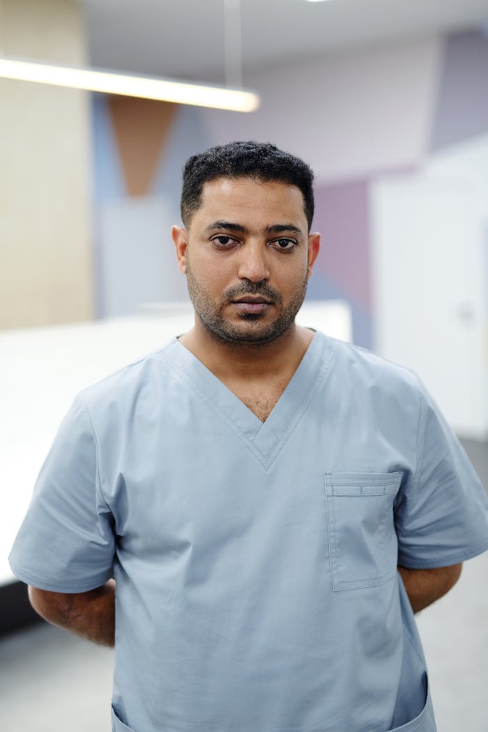 gallery-1 Portrait of a healthcare worker in scrubs standing inside a modern facility.